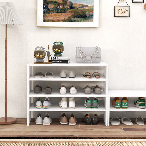 Shoe rack with various shoes in a room with a lamp, plant, and framed picture on the wall.